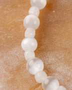 Pulsera de Selenita y Piedra Luna puesta, asomando desde el bolsillo