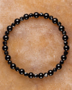 Pulsera de Espinela Negra y Turmalina Negra, pieza completa sobre superficie de mármol claro