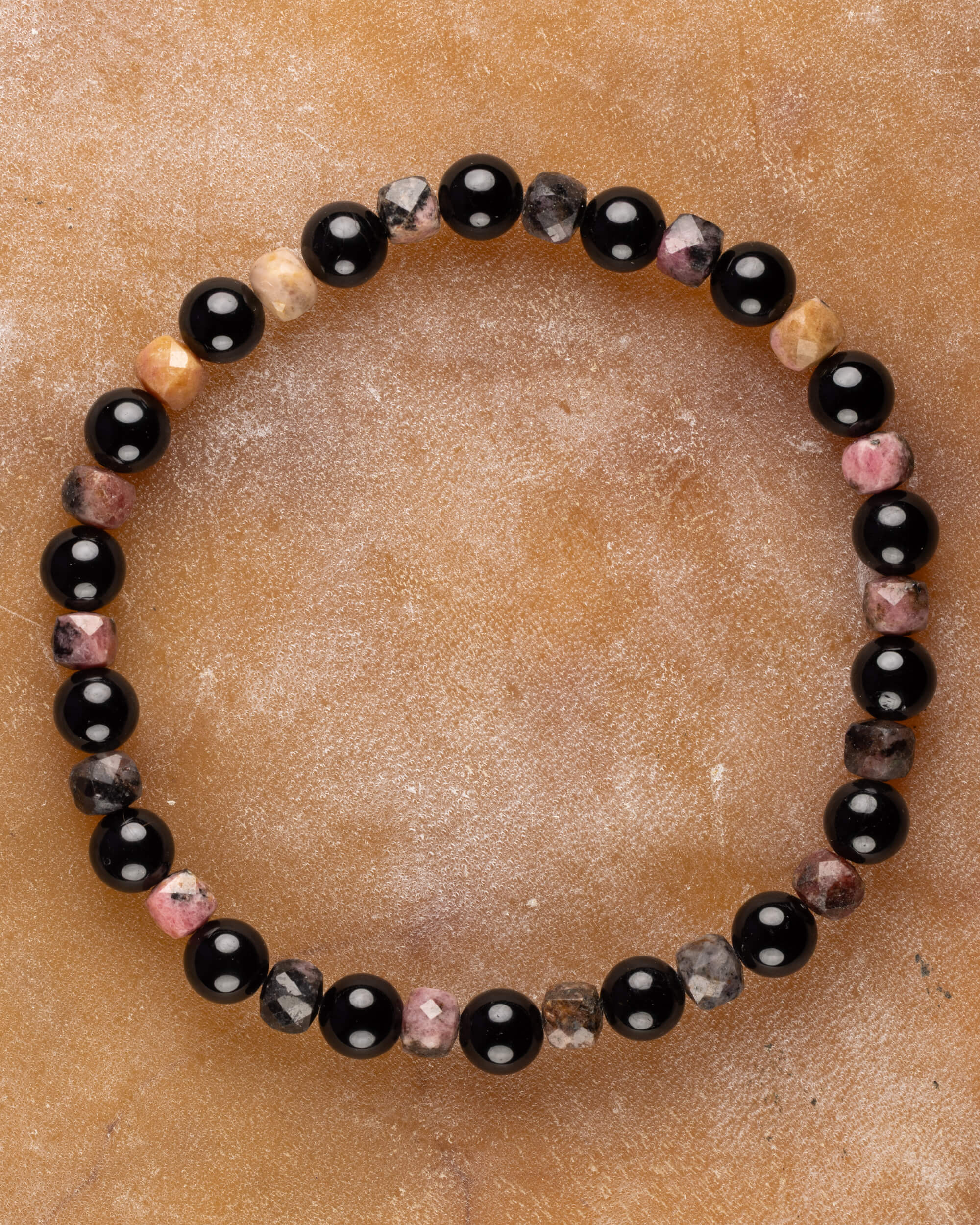 Pulsera de Turmalina Negra y Rodonita de Encaje Negro, pieza completa sobre superficie de mármol claro