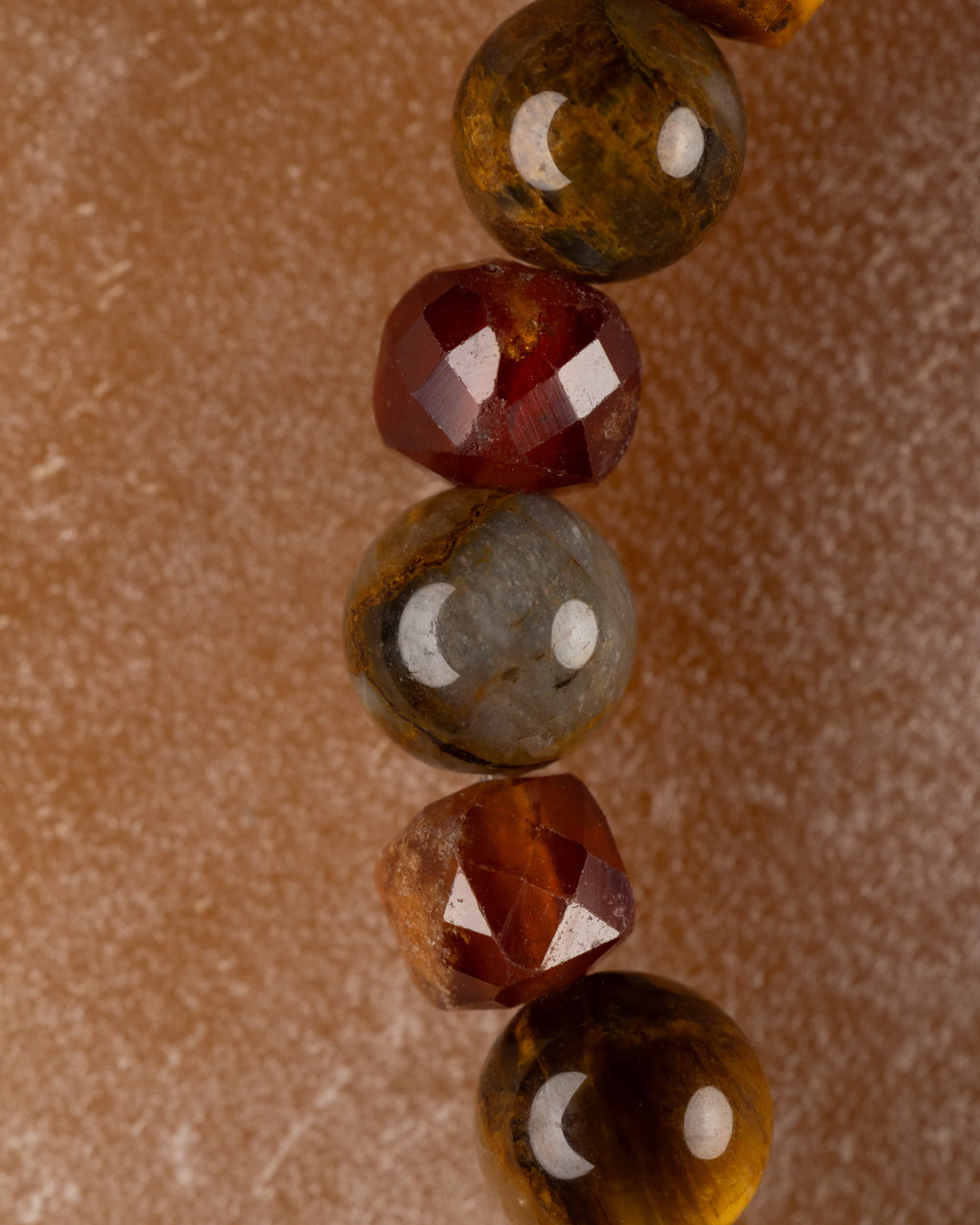 Vista vertical de las cuentas de Pietersita y Granate Espesartina de la pulsera