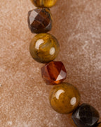 Detalle macro de las cuentas facetadas de Pietersita con destello dorado