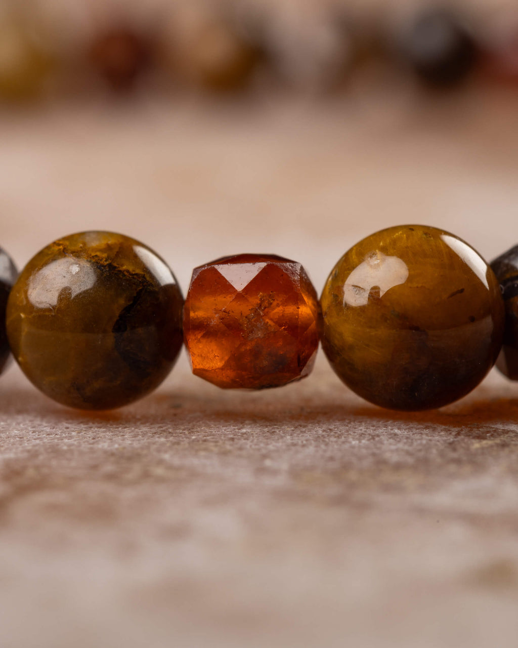 Detalle macro de una cuenta facetada de Granate Espesartina entre Pietersita
