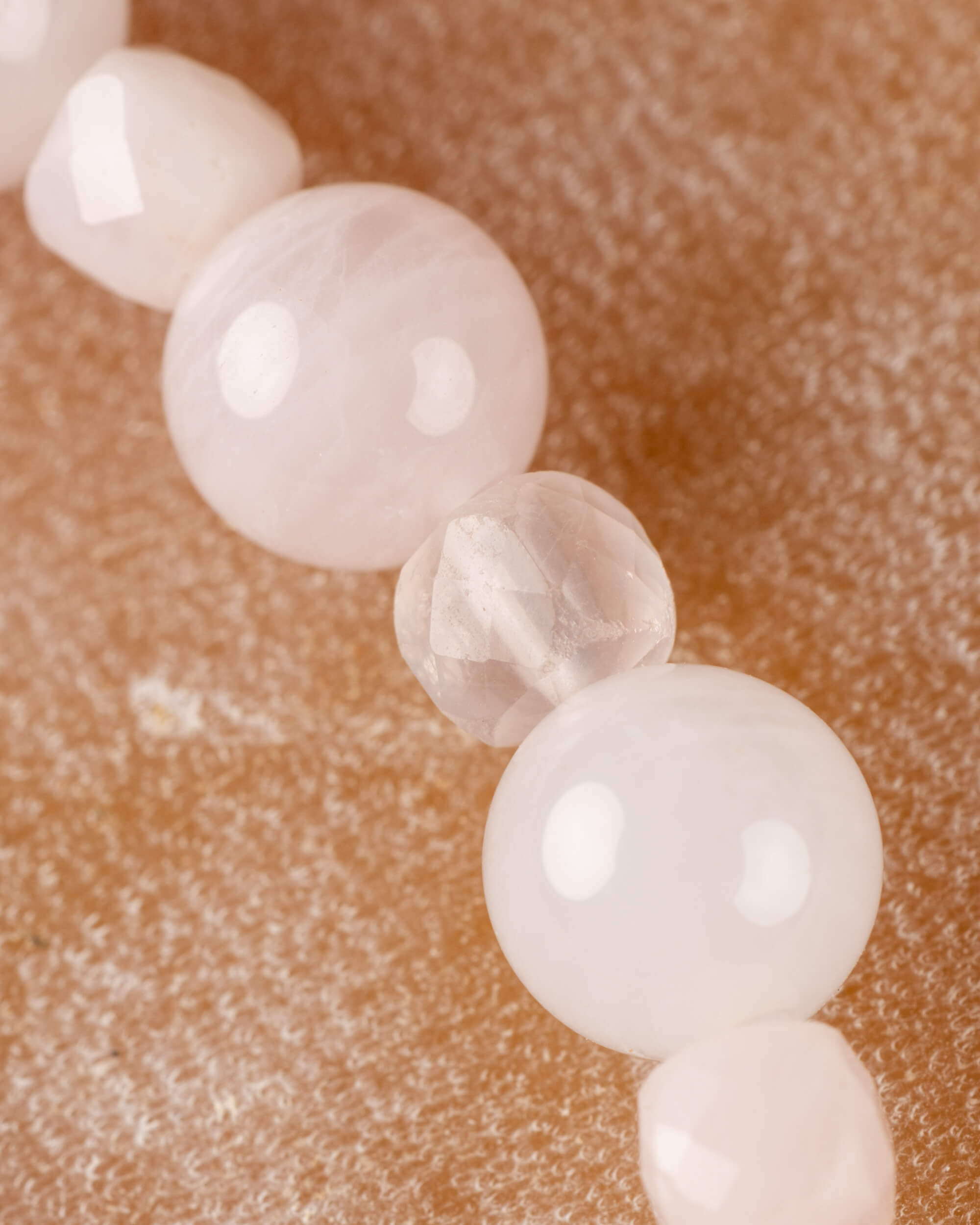 Detalle macro de las cuentas de Cuarzo Rosa con una faceta transparente