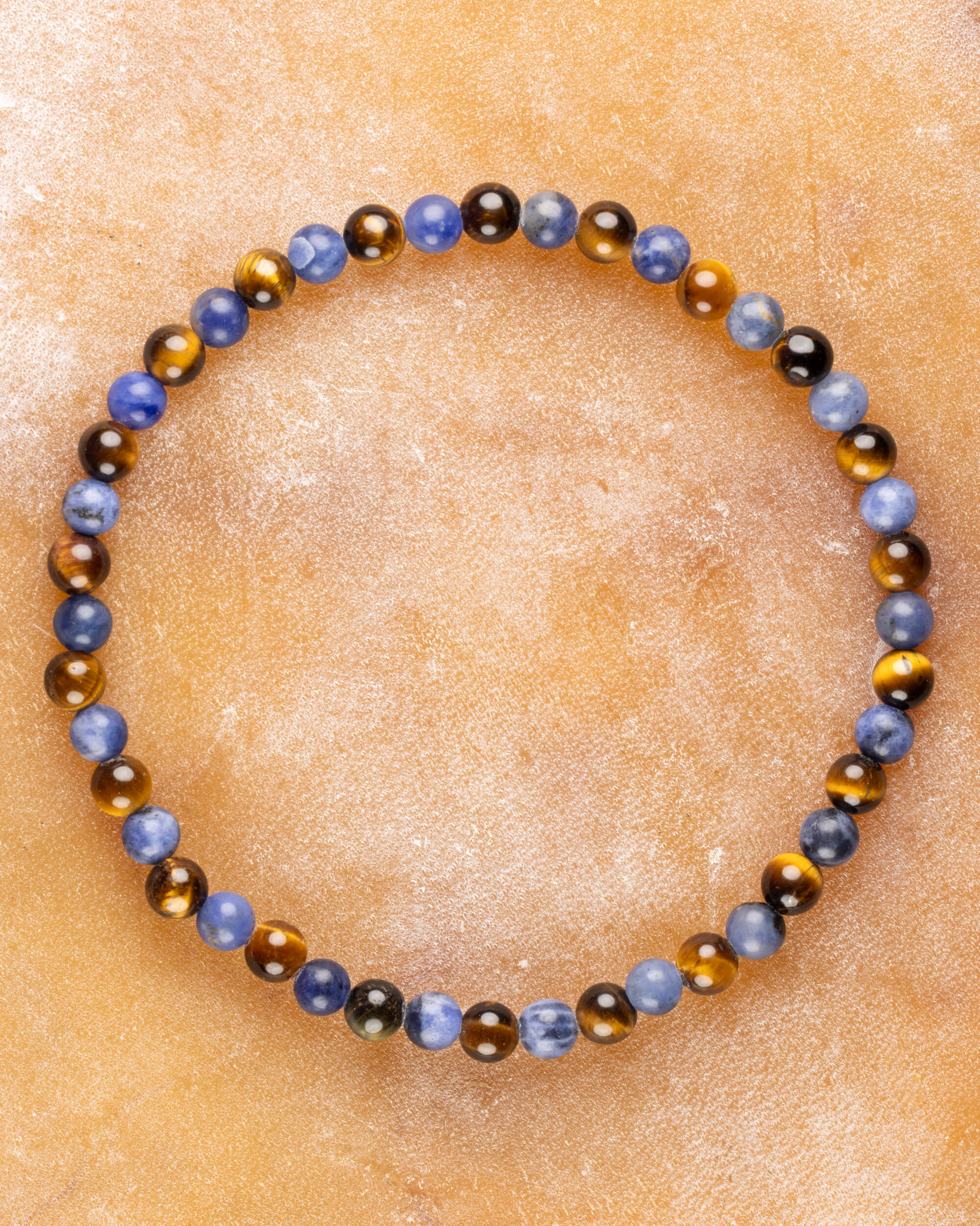 Pulsera de Sodalita y Ojo de Tigre, pieza completa en círculo sobre superficie clara