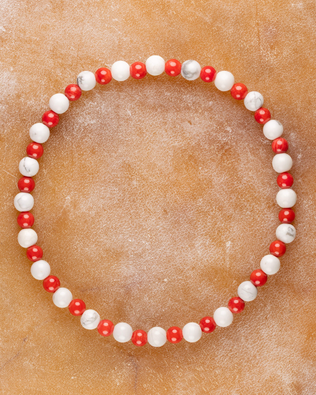 Pulsera de Coral Rojo y Howlita, pieza completa en círculo sobre superficie clara