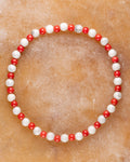 Pulsera de Coral Rojo y Howlita, pieza completa en círculo sobre superficie clara