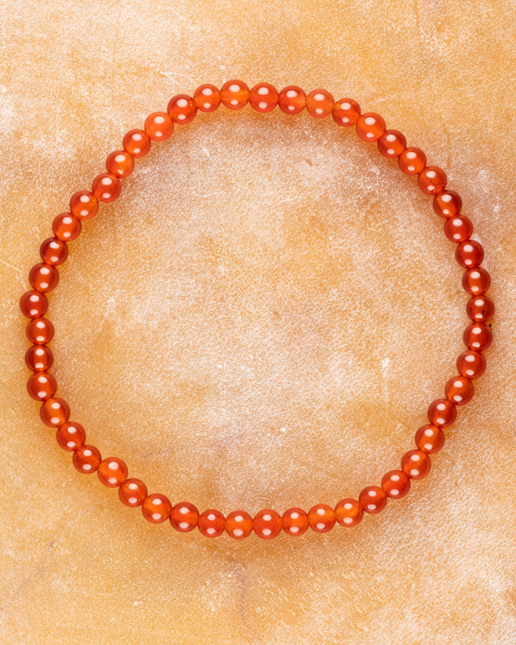 Pulsera de Cornalina de 4 mm, pieza completa sobre superficie cálida