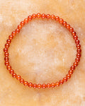 Pulsera de Cornalina de 4 mm, pieza completa sobre superficie cálida