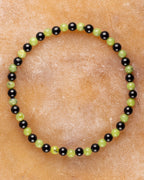 Pulsera de Turmalina Negra y Jade Verde, pieza completa en círculo sobre superficie clara