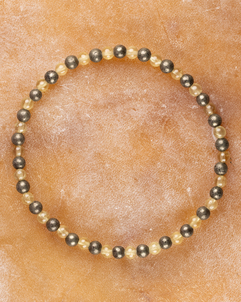 Pulsera de Cuarzo Rutilado y Pirita, pieza completa en círculo sobre superficie clara