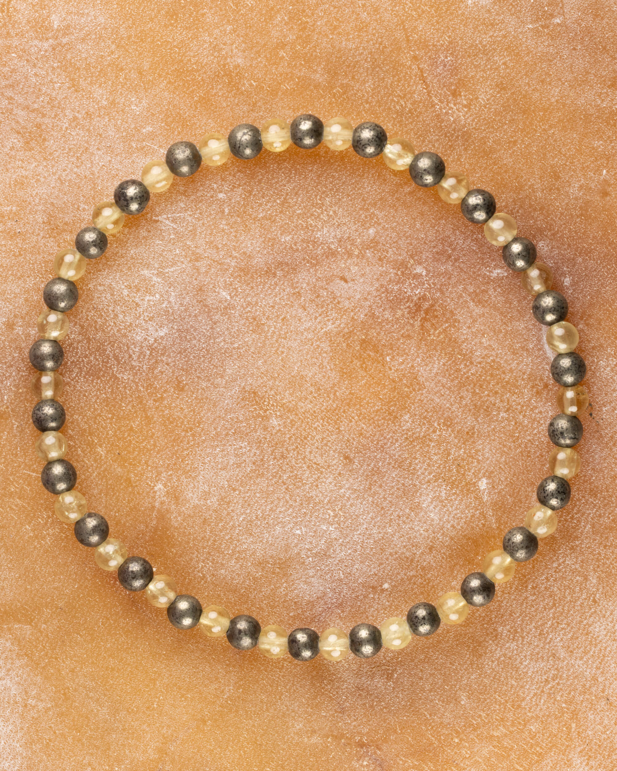 Pulsera de Cuarzo Rutilado y Pirita, pieza completa en círculo sobre superficie clara
