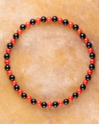 Pulsera de Coral Rojo y Turmalina Negra, pieza completa en círculo sobre superficie clara