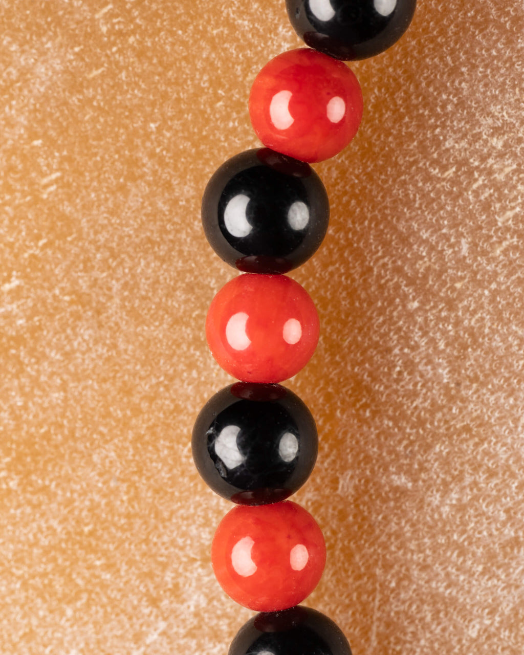 Cuentas de Coral Rojo y Turmalina Negra en perspectiva vertical, detalle macro