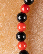 Cuentas de Coral Rojo y Turmalina Negra en perspectiva vertical, detalle macro