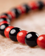 Pulsera de Coral Rojo y Turmalina Negra en curva, cuentas en primer plano