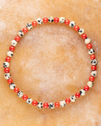 Pulsera de Jaspe Dálmata y Coral Rojo, pieza completa en círculo sobre superficie clara
