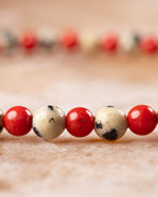 Pulsera de Jaspe Dálmata y Coral Rojo vista de perfil sobre superficie clara