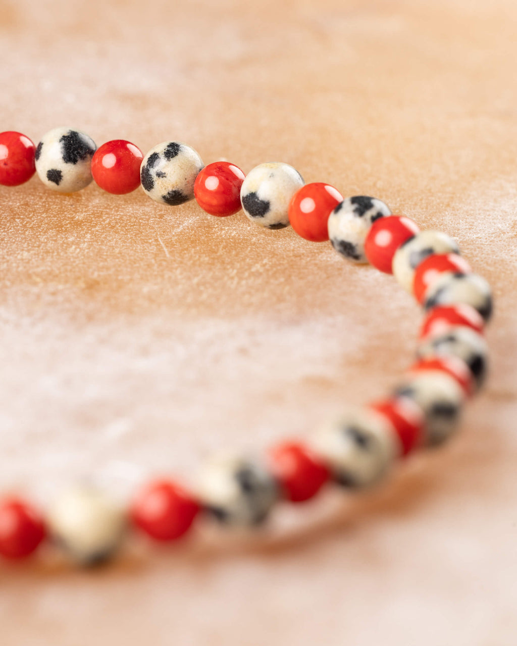 Pulsera de Jaspe Dálmata y Coral Rojo en curva, detalle de las cuentas