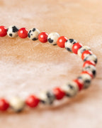 Pulsera de Jaspe Dálmata y Coral Rojo en curva, detalle de las cuentas