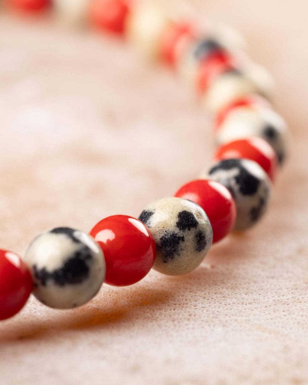 Pulsera de Jaspe Dálmata y Coral Rojo en ángulo cercano, cuentas en primer plano