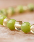 Cuentas de Jade Verde y Cuarzo Rutilado en perspectiva vertical, detalle macro