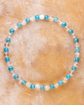 Pulsera de Apatita Azul y Cuarzo Transparente, pieza completa sobre superficie cálida