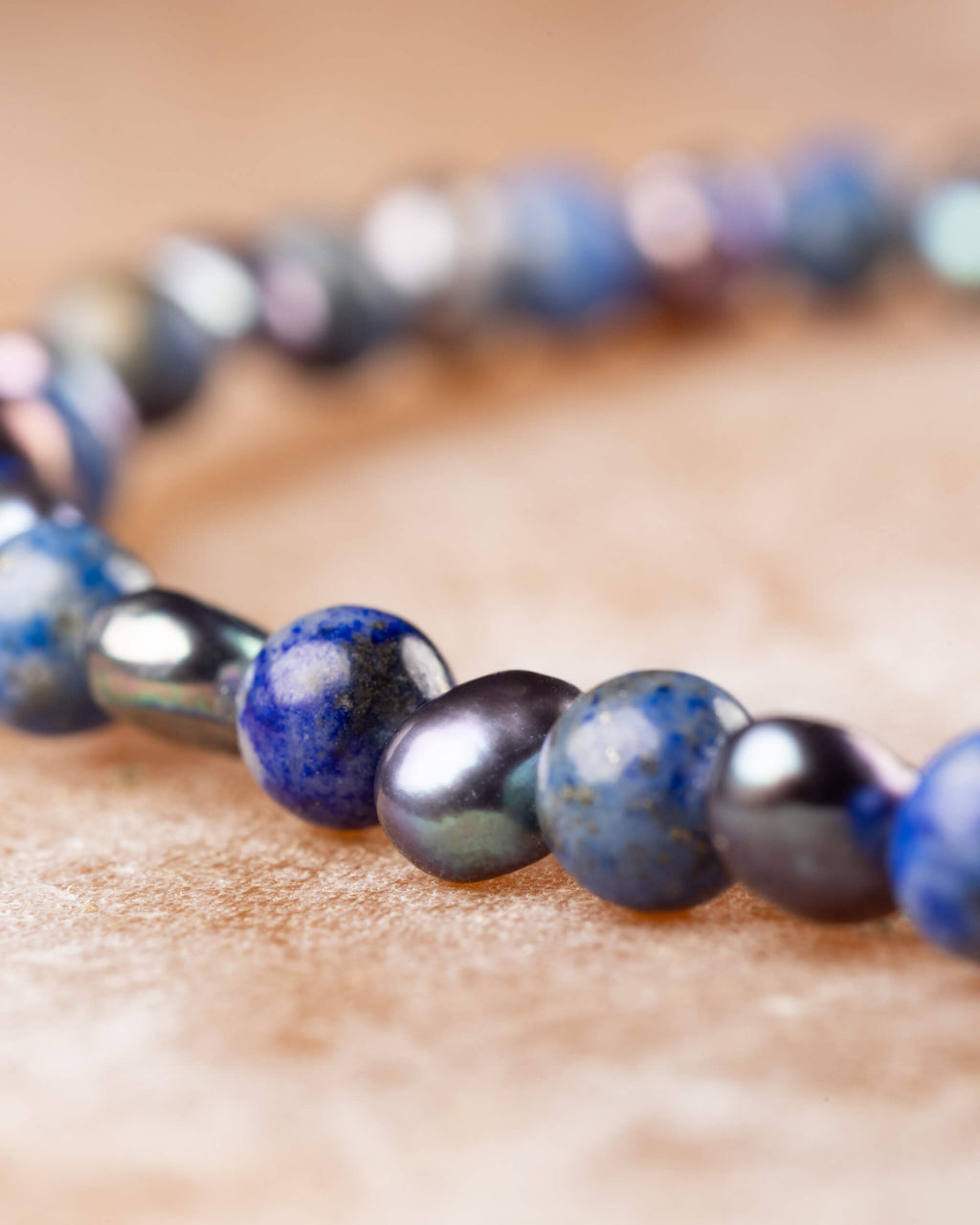 Detalle macro de la pulsera de Lapislázuli y Perla Negra en perspectiva curva