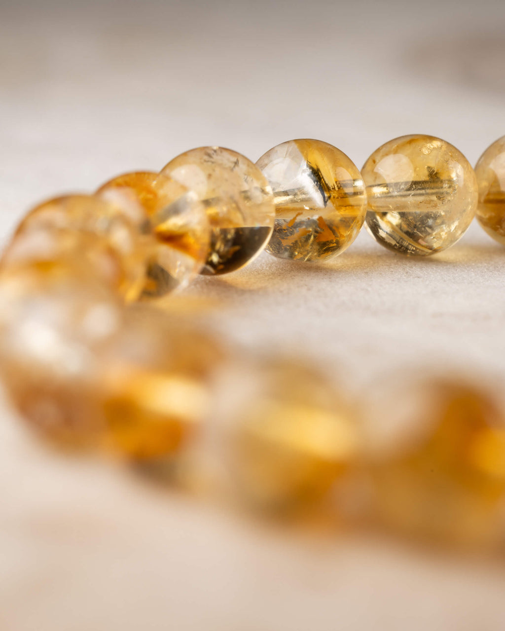 Pulsera de Citrino en angulo cercano, cuentas transparentes con luz calida
