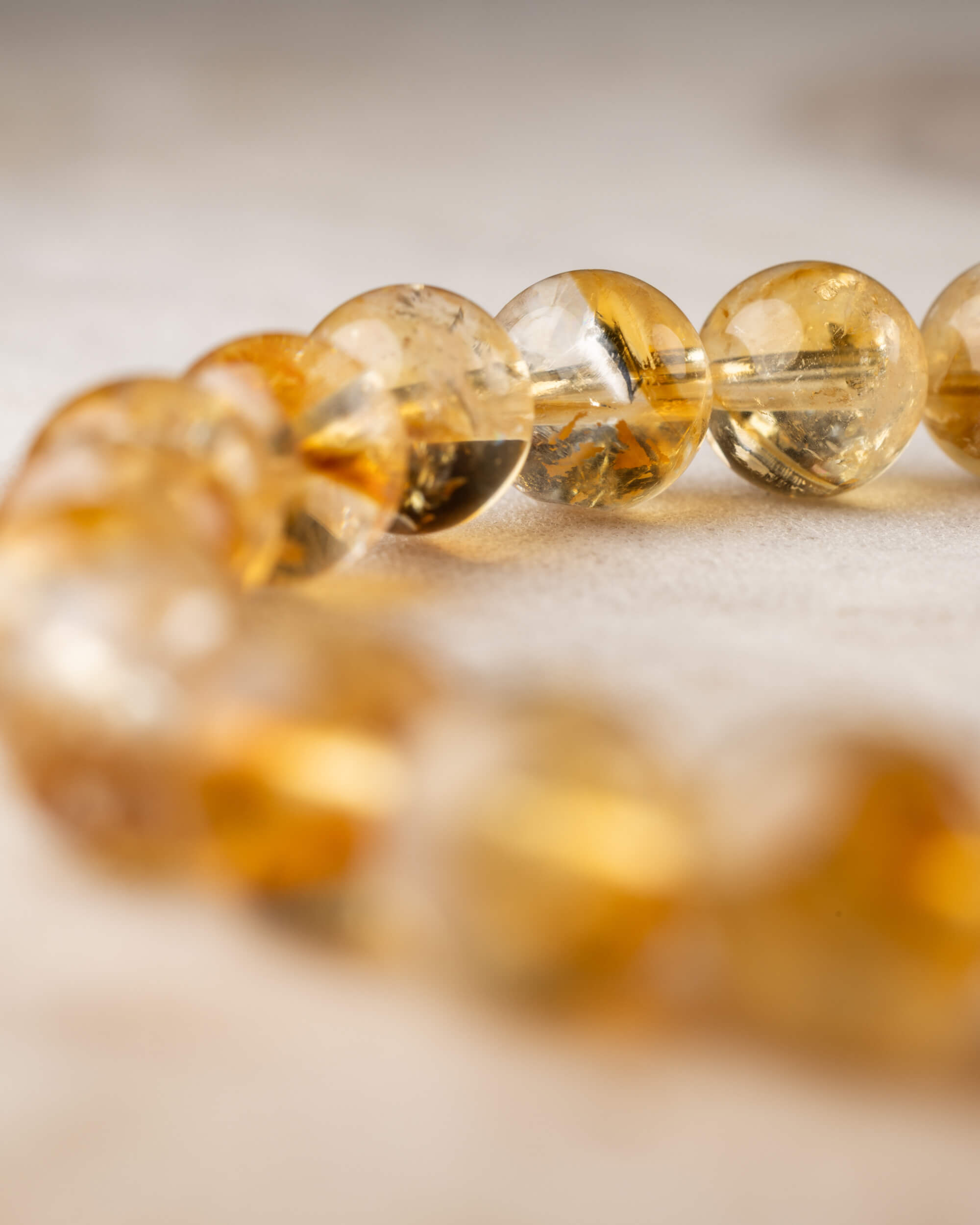 Pulsera de Citrino en angulo cercano, cuentas transparentes con luz calida