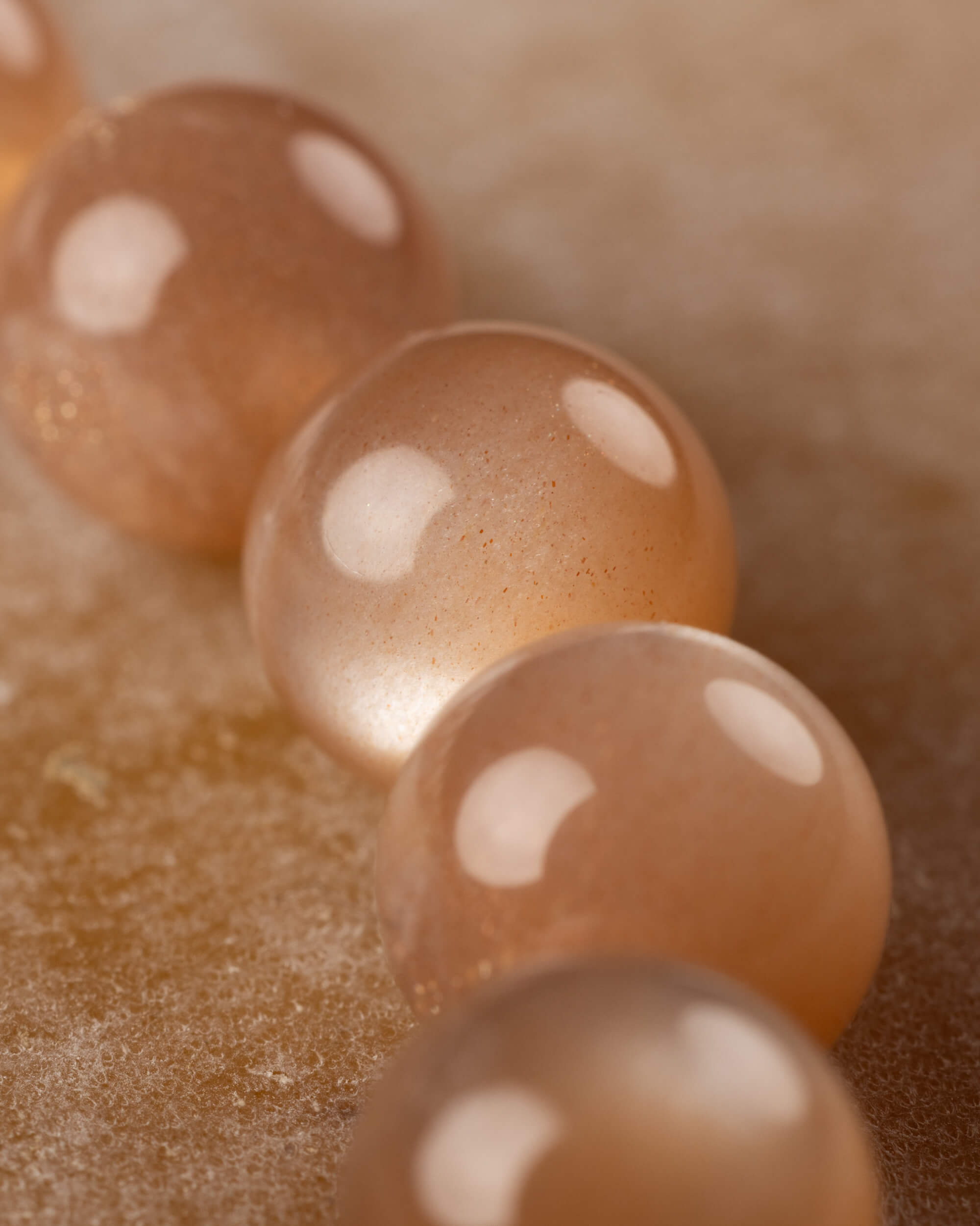 Detalle macro de las cuentas redondas de Piedra Sol Naranja con destellos