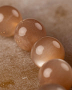 Detalle macro de las cuentas de Piedra Sol Naranja con destellos dorados y fondo claro