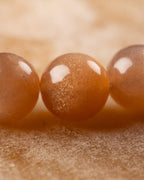 Detalle macro de las cuentas brillantes de Piedra Sol Naranja