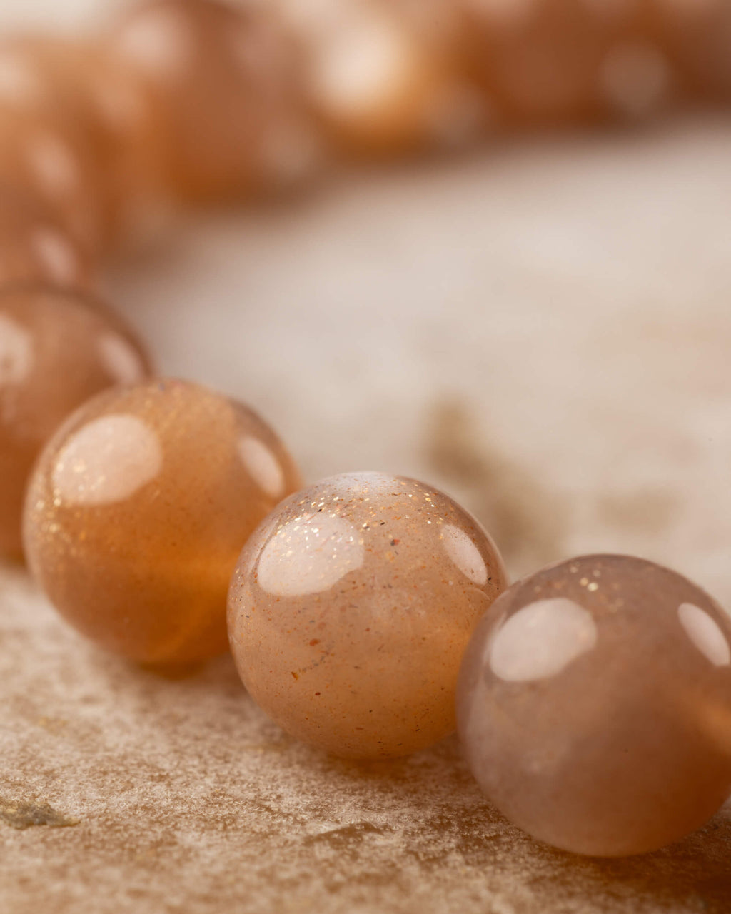 Detalle macro de las cuentas brillantes de Piedra Sol Naranja con reflejos de luz
