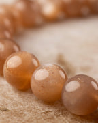 Detalle macro de las cuentas brillantes de Piedra Sol Naranja con reflejos de luz