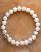 Pulsera de Howlita, pieza completa en círculo sobre superficie ambar