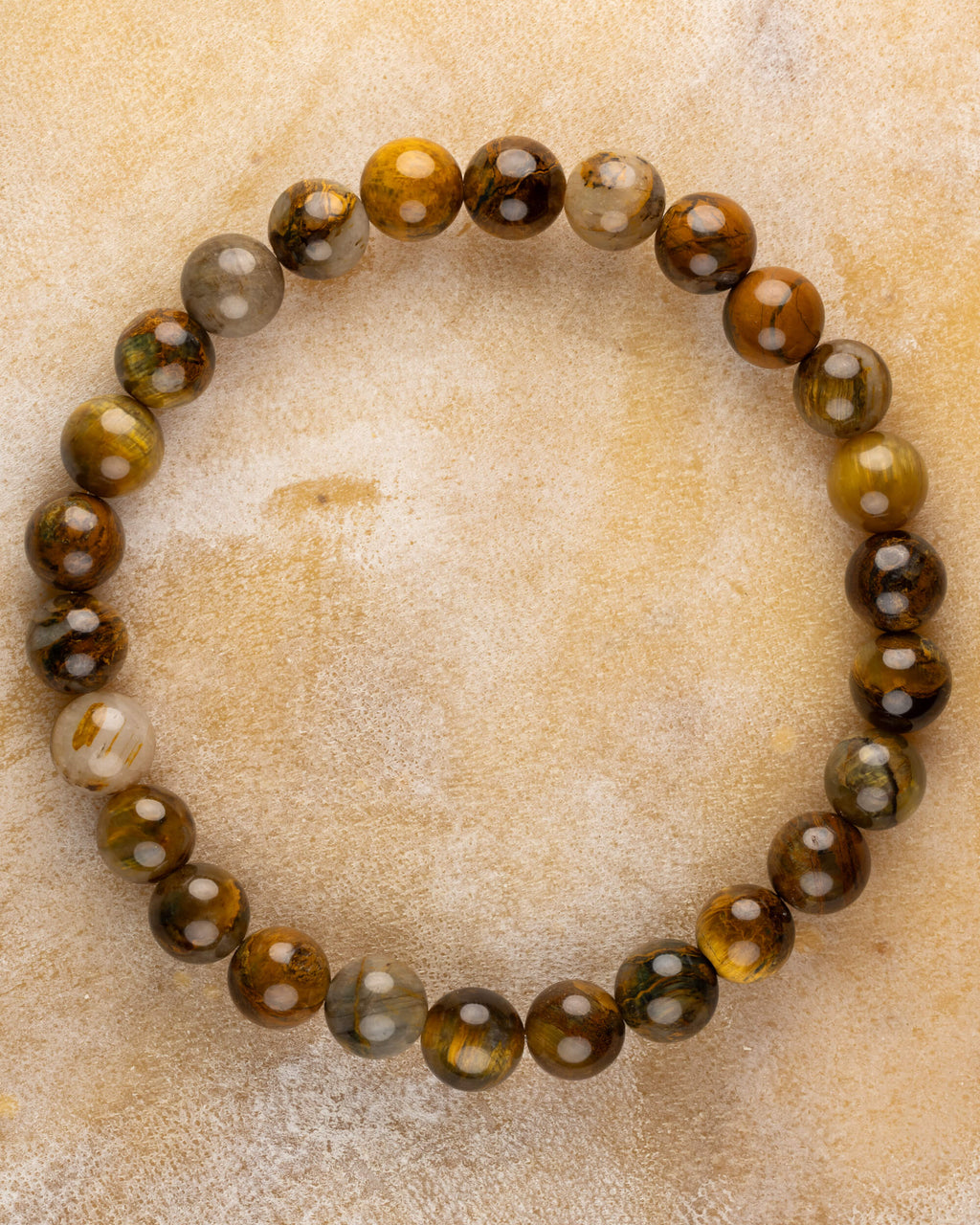 Pulsera de Pietersita Amarilla de 8 mm, pieza completa en círculo sobre superficie clara