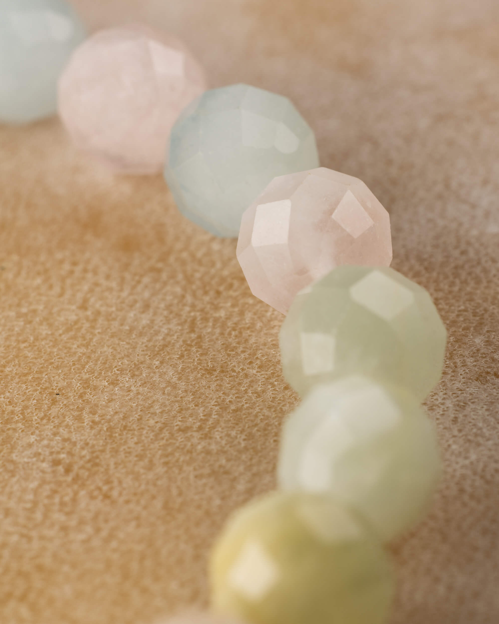 Detalle macro de cuentas facetadas de Berilos en tonos rosa, verde y azul