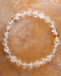 Pulsera de Cuarzo Transparente de 8 mm, pieza completa sobre superficie de piedra clara