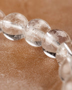 Detalle macro de cuentas de Cuarzo Transparente con vetas internas visibles
