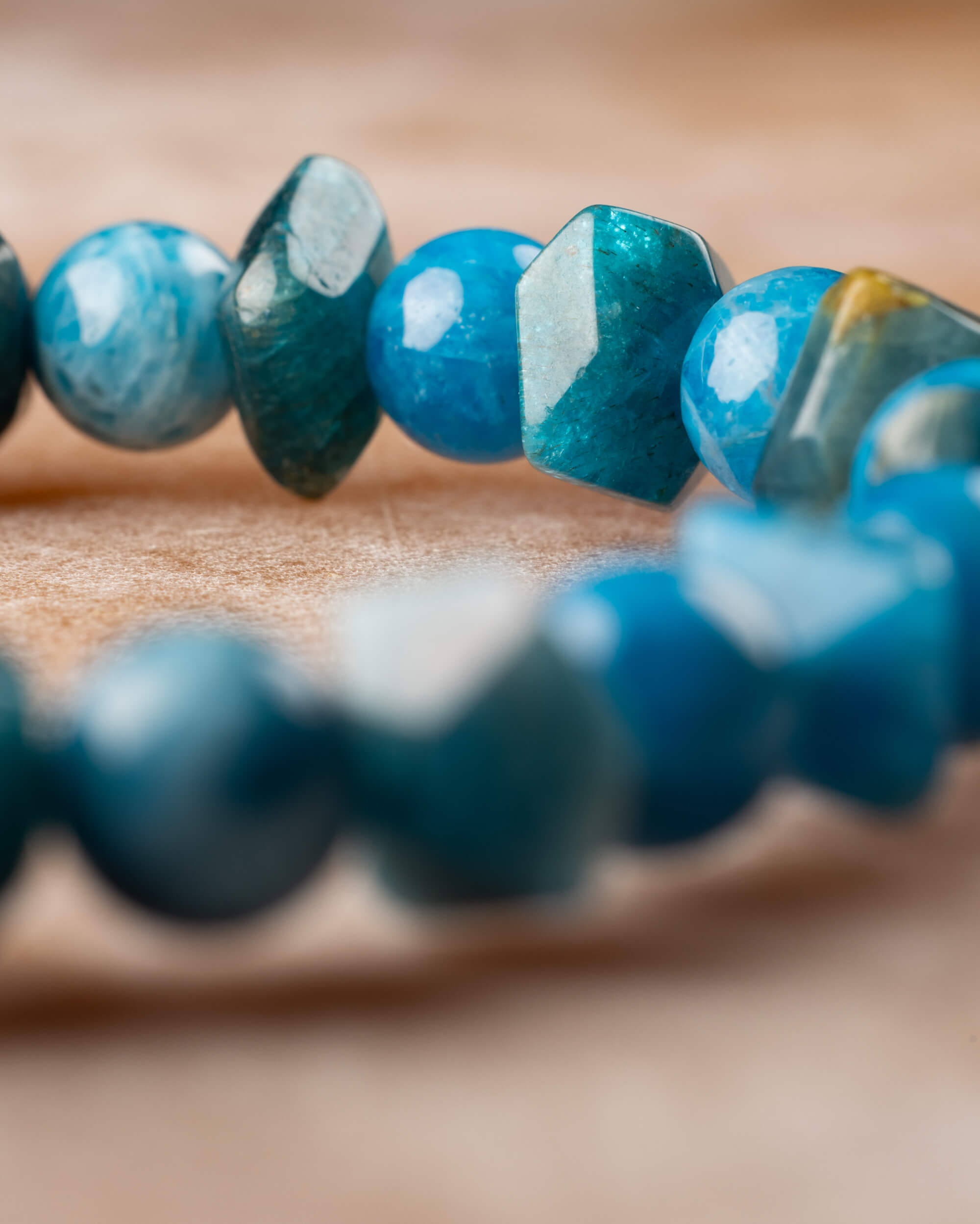 Pulsera de Apatita Azul en curva, cuentas facetadas y redondas sobre superficie clara