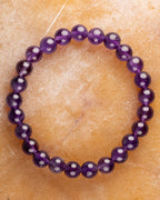 Pulsera de Amatista de 8 mm, pieza completa sobre superficie dorada