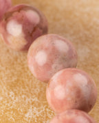 Detalle macro de las cuentas de Rodonita Rosa con manchas redondas claras sobre su superficie