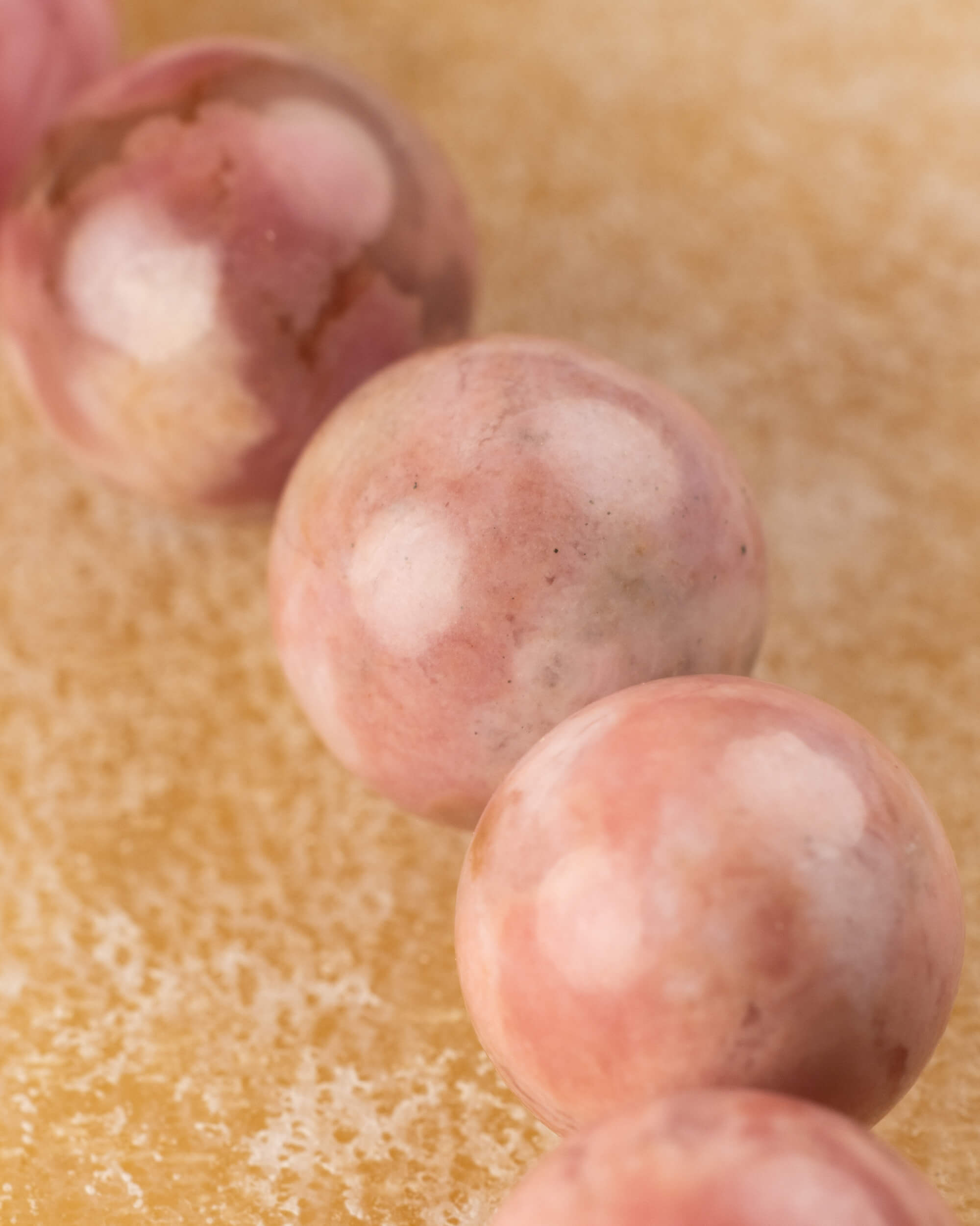 Detalle macro de las cuentas de Rodonita Rosa con manchas redondas claras sobre su superficie