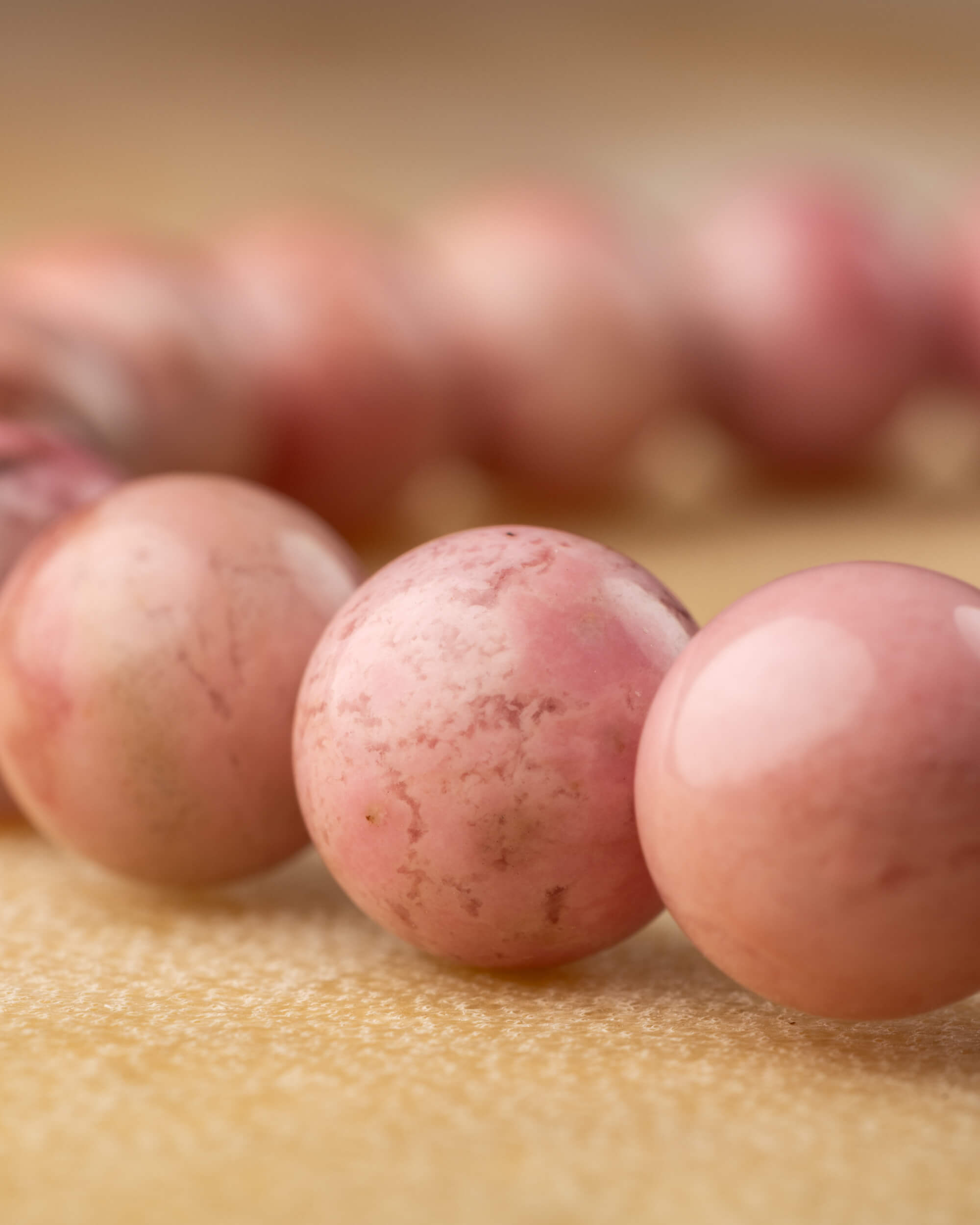 Detalle macro de las cuentas de Rodonita Rosa con vetas y motas naturales