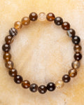 Pulsera de Ágata Grano de Café de 8 mm, pieza completa en círculo sobre superficie dorada