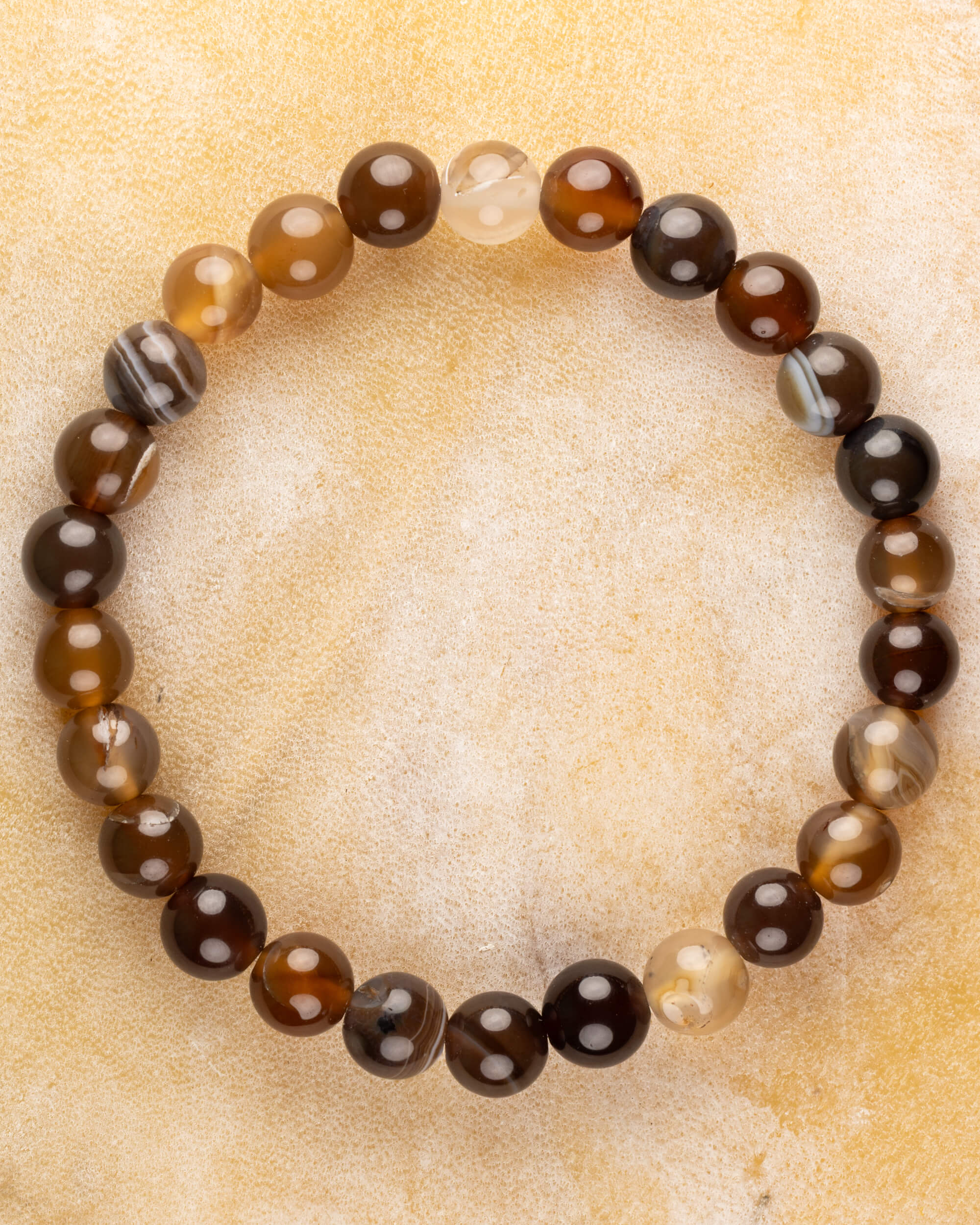 Pulsera de Ágata Grano de Café de 8 mm, pieza completa en círculo sobre superficie dorada