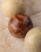 Detalle macro de una cuenta terracota de Shoushan entre cuentas beige