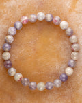 Pulsera de Turmalina Rosa de 8 mm, pieza completa en círculo sobre superficie de mármol color miel