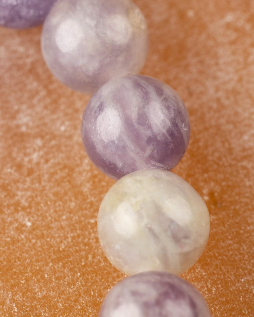 Detalle macro de cuentas lavanda y crema de Turmalina Rosa