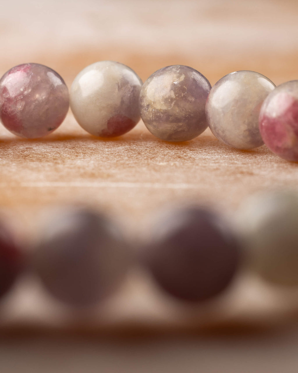 Detalle macro de las cuentas de Turmalina Rosa con manchas rosas y fondo oscuro